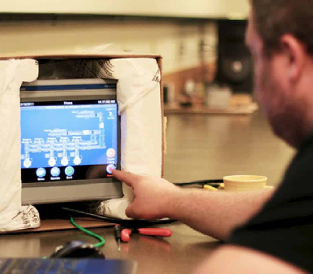 Process Solutions engineer programming scada software on an HMI screen
